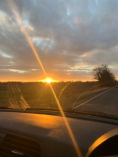 the sun is setting over an empty road