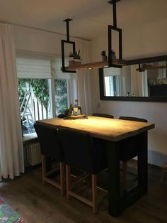 a dining room table and chairs in front of a window