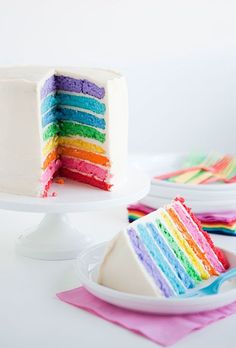 a rainbow cake with one slice missing from it