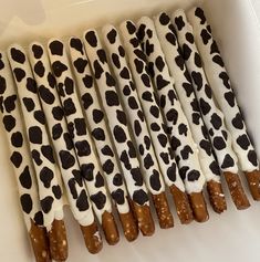 chocolate covered pretzels are lined up in a white box with black spots on them