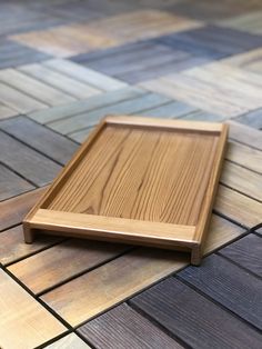 a wooden tray sitting on top of a tiled floor