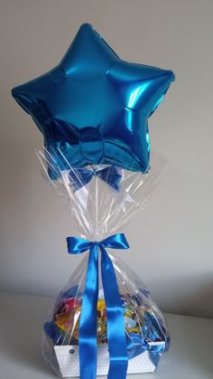 a star shaped balloon wrapped in plastic and tied with blue ribbon