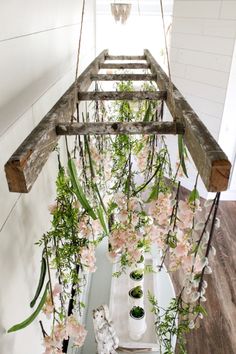 an overhead planter with pink flowers and greenery hanging from it's sides