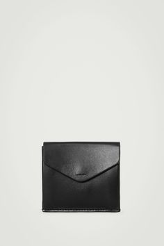 Our leather goods are expertly crafted for the demands of modern life. This wallet is designed with a folded compartment to store coins and three slots at the back to keep your cards at hand. The premium hide is scratch resistant and tanned in enduring brown hue using a chrome-free dyeing process. Press-stud closureDebossed COS logoCOS supports responsible manufacturing via the Leather Working Group  Shell: 100% Leather. Lining: 100% Cotton. Excluding trims Height: 3.34", Width: 3.74" Everyday Black Trifold Wallet With Smooth Grain, Black Leather Trifold Wallet For Everyday, Classic Leather Envelope Coin Purse, Everyday Leather Envelope Card Holder, Black Trifold Wallet With Coin Pocket For Everyday, Minimalist Business Wallets With Interior Card Slots, Everyday Envelope Wallet With Rfid Blocking, Minimalist Envelope Wallet For Daily Use, Black Leather Coin Purse For Everyday