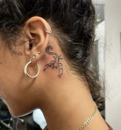 a woman with a small tattoo behind her ear