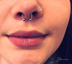 a woman's nose has two piercings on it