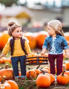 two dolls are standing next to each other in front of pumpkins