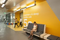 a woman sitting on a bench in front of a sign that reads 5 / 55