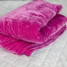 two bright pink pillows are stacked on top of each other