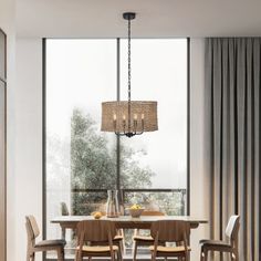 a dining room table with chairs and a chandelier in front of large windows