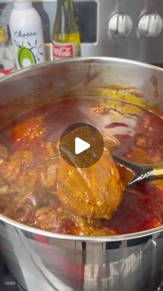 a ladle full of meat and vegetables being stirred in a pot