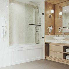 a bathroom with a sink, mirror and bathtub next to a wall mounted shower head