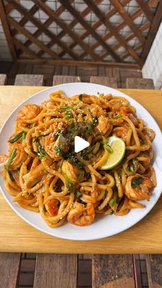 a white plate topped with pasta and shrimp