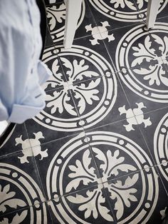 a black and white tile floor with an intricate design on the top part of it