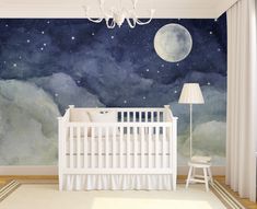 a baby's room with a crib and wall mural