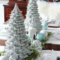 silver and white christmas decorations on a dining room table