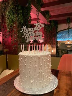 a white birthday cake with candles on top