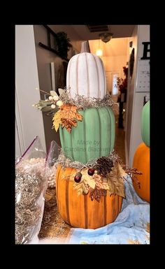 a three tiered pumpkin decorated with leaves and acorns