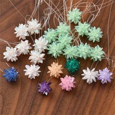 small plastic snowflakes are on a wooden table with string and twine