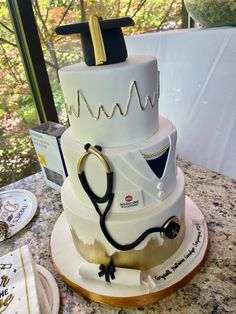 a three tiered cake with a stethoscope on top is sitting on a table