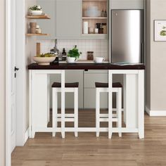 a kitchen with two stools and a refrigerator