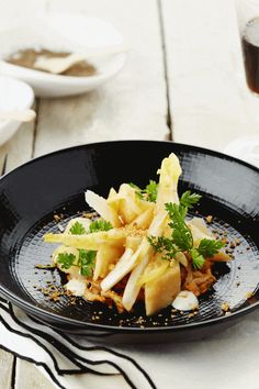 a black plate topped with food on top of a table