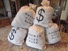 five bags filled with money sitting on top of a counter