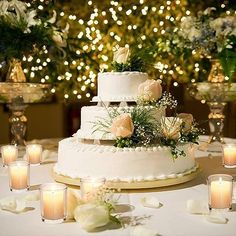 a wedding cake with flowers and candles on the table