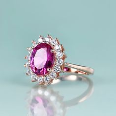 Inspired by Princess Diana’s Engagement Ring and Kate Middleton’s Engagement Ring This beautiful Princess Diana engagement ring with pink sapphire is inspired by Princess Diana's engagement ring, which is a 12-carat oval sapphire surrounded by 14 round diamonds set in 18-karat white gold. It is also Kate Middleton's engagement ring. It Features a Pink Sapphire Stone With Vivid Colors This pink sapphire ring features one lab-created pink sapphire stone and 16 clear cubic zirconia stones. Sapphire Princess Diana Engagement, Kate Middleton Engagement Ring, Princess Diana Engagement Ring, Diana Engagement Ring, Sapphire Birthstone Ring, Engagement Ring Pink, Princess Diana Ring, Sterling Silver Birthstone Ring, Diana Ring