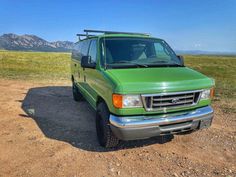 a green van is parked in the dirt