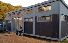 the tiny house is built on wheels and has windows that look like they are made out of wood