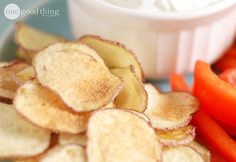 a plate with chips, carrots and dip on it