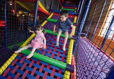 two young children playing in an indoor trampoline