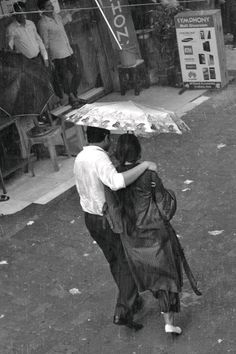 black and white photograph of two people under an umbrella