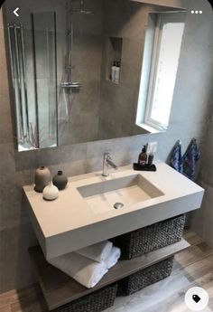 a white sink sitting under a bathroom mirror