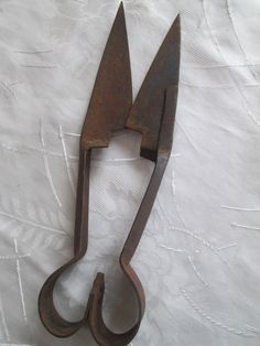 an old pair of scissors sitting on top of a white sheet