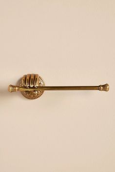 a gold toilet brush mounted on the wall