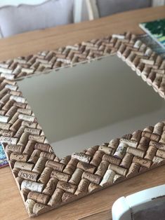 a mirror made out of cork sitting on top of a wooden table next to a chair