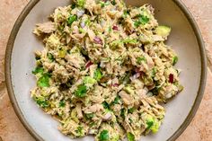 a white bowl filled with chicken salad on top of a table