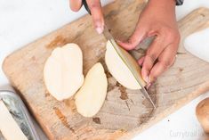 a person cutting apples on a wooden cutting board