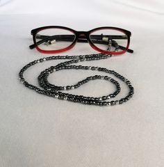 Sunglasses chain Eyeglasses chain Glasses necklace Glasses holder This chain is made of black glass beads and silver hematite beads with a diameter of 4 mm. The metal parts and buckle are stainless steel. The chain is ideal for all people who wear glasses and often have to take off their glasses. Simply hang them on the necklace and they are  always with you. This is a wonderful fashion detail because the chain-necklace is very effective and modern. You can give it to your mother, sister, wife, grandmother ... If you buy this chain, it comes in a nice gift box. We send all shipments by registered mail with a security tracking code. Thanks a lot for visiting! FREE SHIPPING! Elegant Black Metal Glasses Chains, Black Metal Glasses Chain With Adjustable Feature, Black Metal Glasses Chains With Adjustable Chain, Black Metal Glasses Chain With Adjustable Length, Black Adjustable Glasses Chain For Parties, Black Metal Adjustable Glasses Chain, Trendy Black Metal Glasses Chains, Elegant Black Glasses Chains For Party, Trendy Silver Jewelry With Black Beads