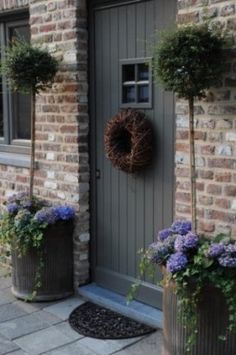 two planters with wreaths on the front door