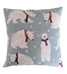 a blue pillow with polar bears and snow flakes on the front, along with a red scarf around its neck