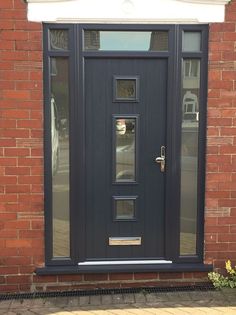 a black front door on a brick building with glass panes and sidelighting