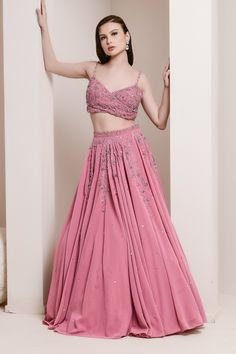 Pink lehenga with crystal and bead floral vine design. Comes with strappy blouse and ruffled edge dupatta.
Components:3
Pattern:Embroidery
Type of Work:Cutdana, Sequins, Crystals, Rhinestones, Zircons, Beads and Swarovski's
Neckline:V neck
Sleeve Type:Sleeveless
Fabric:Georgette and Net
Color:Pink
Other Details:
Overlap style V neck
Shoulder straps
Cutwork detail on the waistband
Closure: Side zip
Occasion:Wedding - Aza Fashions Party Wear Sleeveless Lehenga Hand Embellished, Elegant Floor-length Bridesmaid Choli, Sleeveless Party Wear Lehenga In Georgette, Sleeveless Georgette Lehenga For Party, Sleeveless Party Wear Lehenga For Reception, Embellished Sleeveless Lehenga For Wedding, Sleeveless Hand Embellished Wedding Sets, Hand Embellished Lehenga For Reception, Sleeveless Hand Embellished Lehenga For Wedding