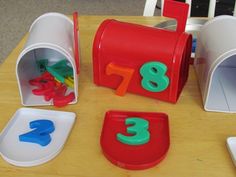 a wooden table topped with plastic numbers and cups filled with magnets on top of it