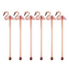 four pink flamingos are lined up in a row