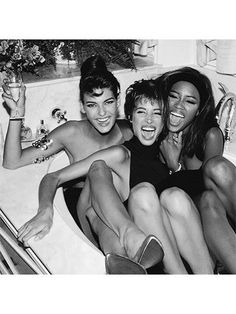 three women sitting in a bathtub with their arms around each other