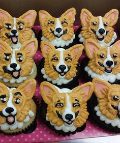 some cupcakes with dogs on them sitting in a box