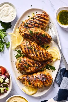 grilled chicken with lemon wedges and garnishes